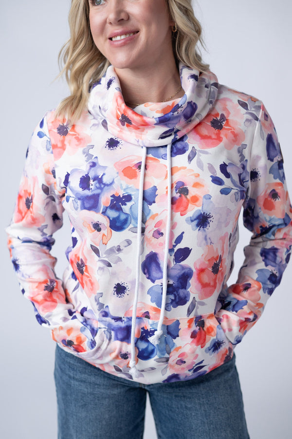 Woman wearing a floral-patterned hoodie against a plain background