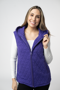 Woman wearing a purple quilted vest against a white background