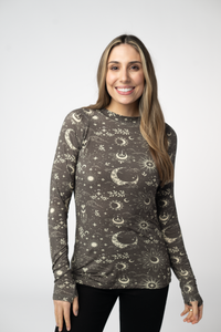 Woman wearing a long-sleeve shirt with celestial pattern on a plain background