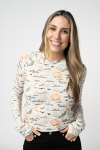 Woman wearing a long-sleeve shirt with a Halloween-themed pattern on a white background