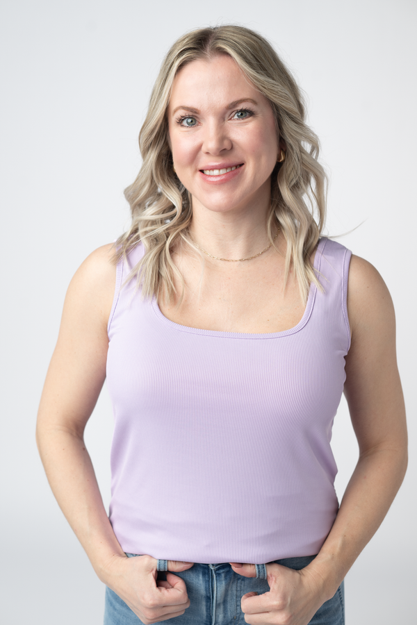 Woman wearing a light purple tank top against a plain background