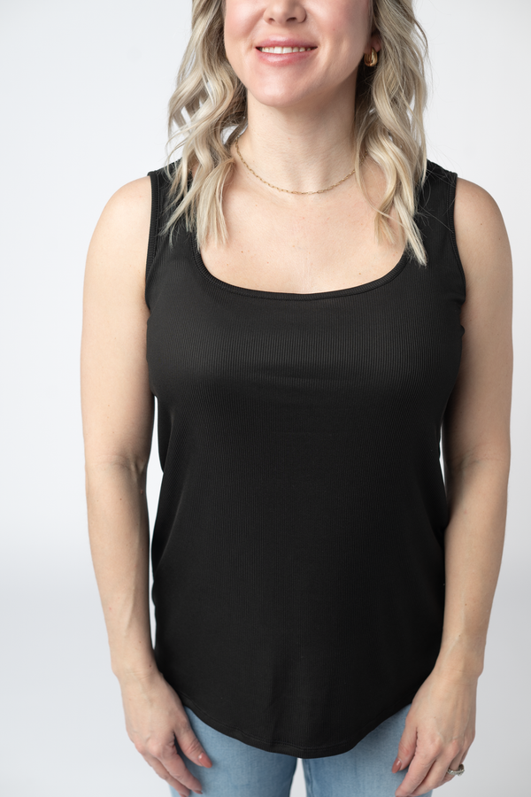 Woman wearing a black tank top against a white background