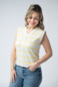 Woman wearing a white and yellow striped sleeveless top with blue jeans on a light gray background