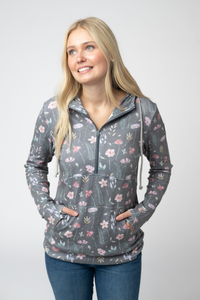 Woman wearing a floral patterned gray pullover with a white background
