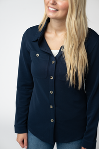 Woman wearing a navy blue button-up shirt against a white background