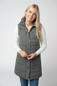 Woman wearing a gray puffer vest on a white background