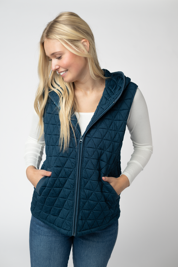 Woman wearing a blue quilted vest on a white background