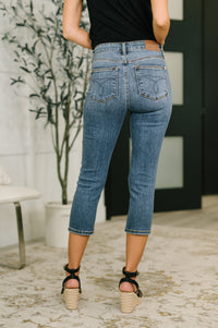 Person wearing blue jeans and black top in an indoor setting