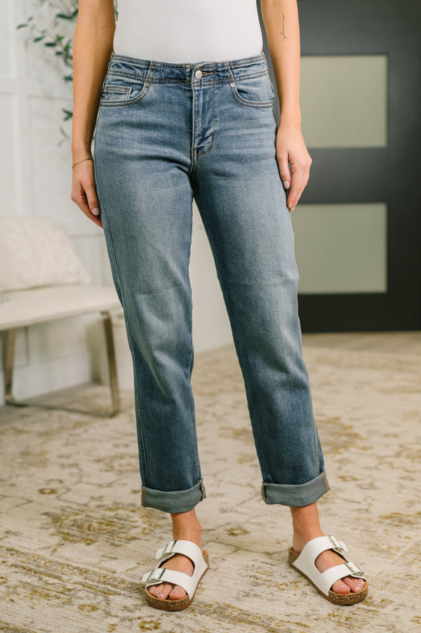 Person wearing blue jeans and white sandals in a casual setting