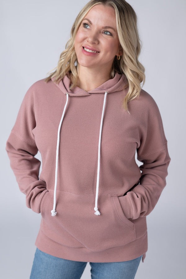 Woman wearing a pink hoodie with a white background