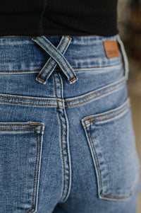 Close-up of blue jeans with a brand label on the back pocket.