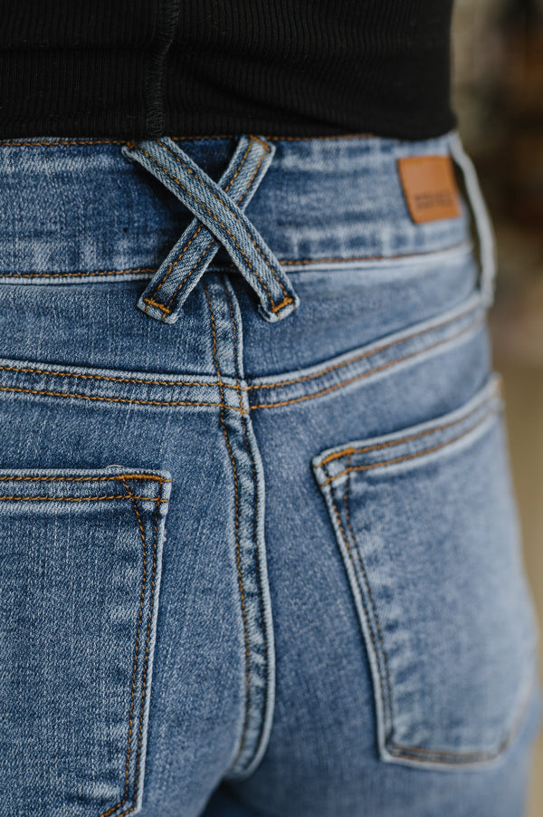 Close-up of blue jeans with a brand label on the back pocket.