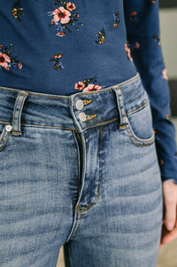 Close-up of blue jeans with floral patterned top