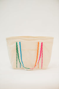 Beige fabric basket with colorful zigzag patterns on a white background