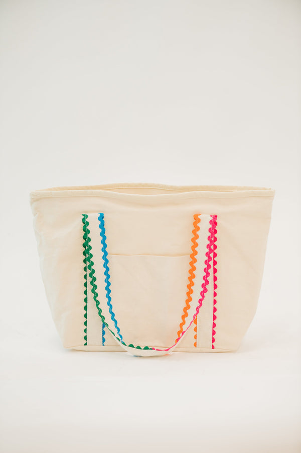 Beige fabric basket with colorful zigzag patterns on a white background