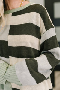 Close-up of a person wearing a green and beige striped sweater.