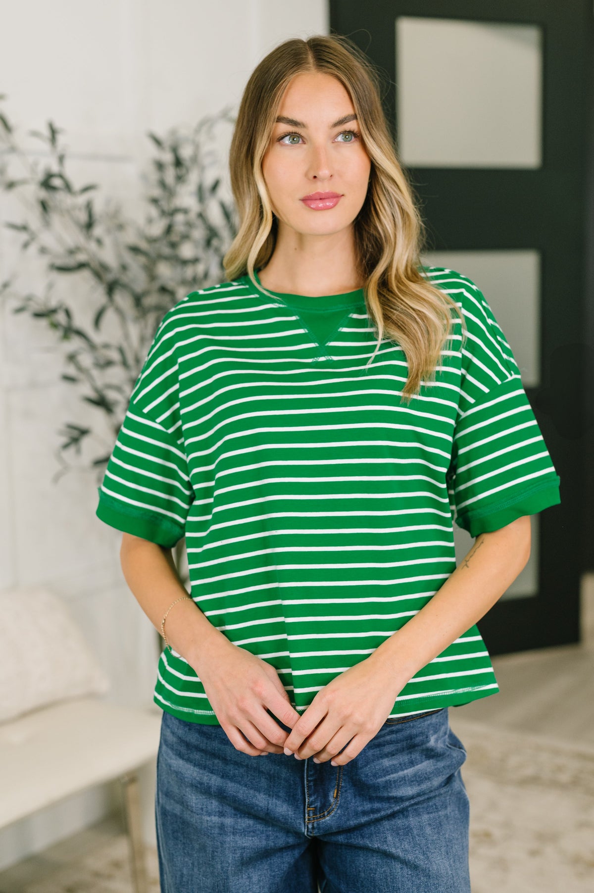 Woman wearing a green and white striped shirt in an indoor setting