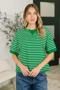 Woman wearing a green and white striped shirt in an indoor setting