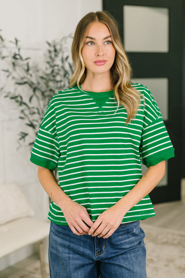 Woman wearing a green and white striped shirt in an indoor setting