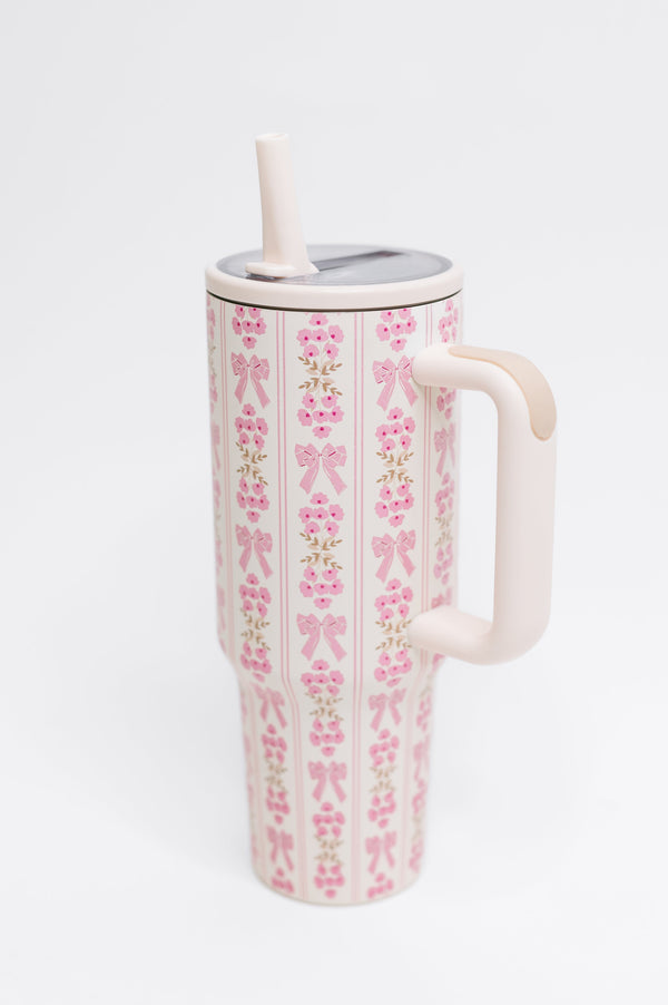 Tumbler with pink bow pattern on a white background