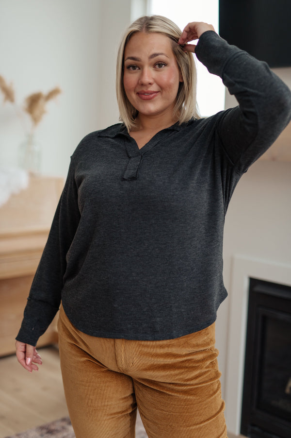 Person wearing a dark gray hoodie and mustard yellow pants indoors.