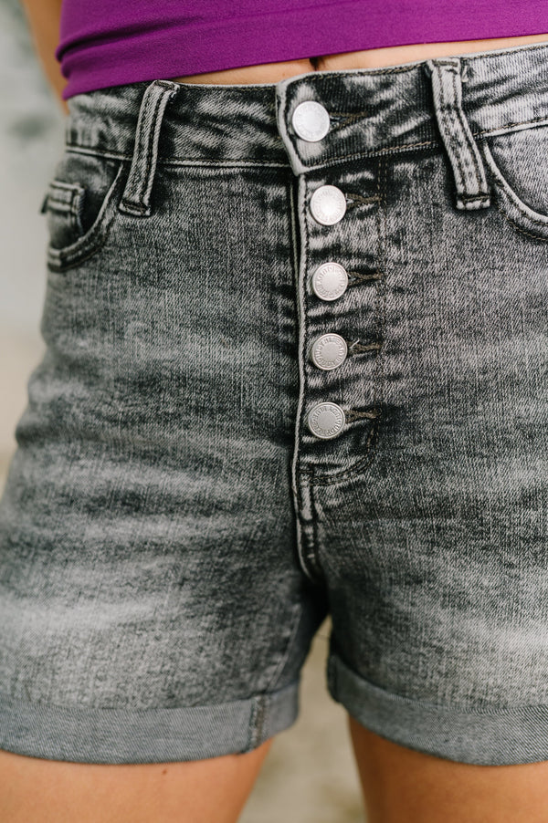 Gray denim shorts with button details on a blurred background