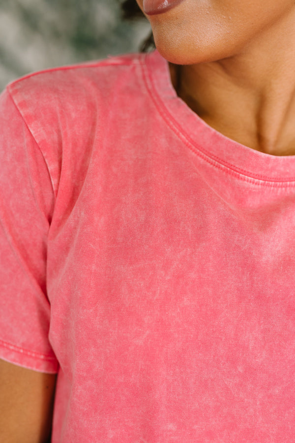 Close-up of a person wearing a pink t-shirt with a blurred background
