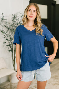 Woman wearing a blue shirt and light shorts indoors