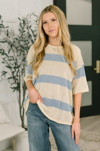 Woman wearing a striped shirt and jeans in a living room setting