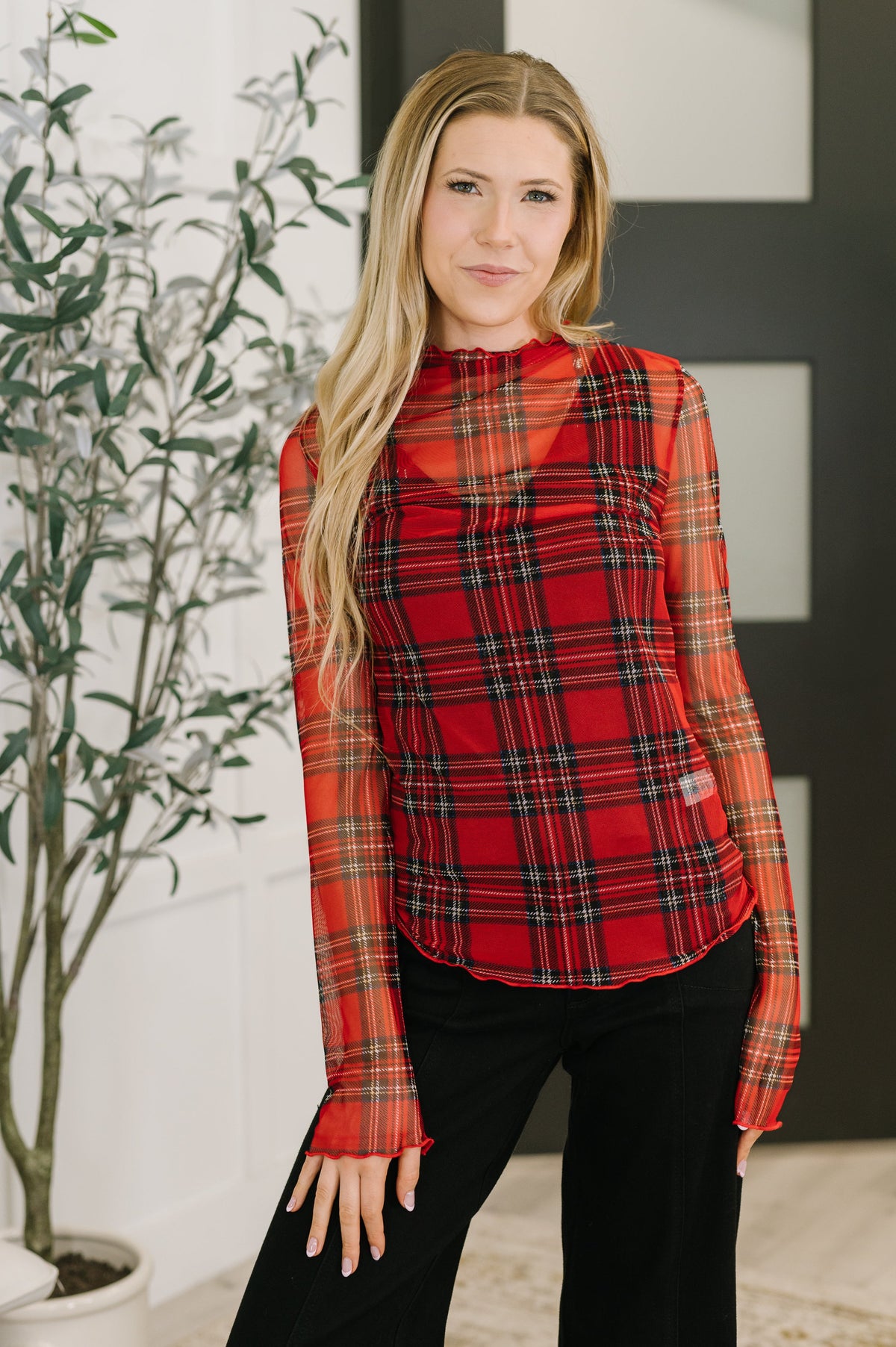 Woman wearing a red plaid shirt in an indoor setting