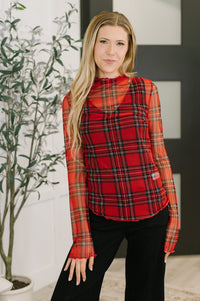 Woman wearing a red plaid shirt in an indoor setting