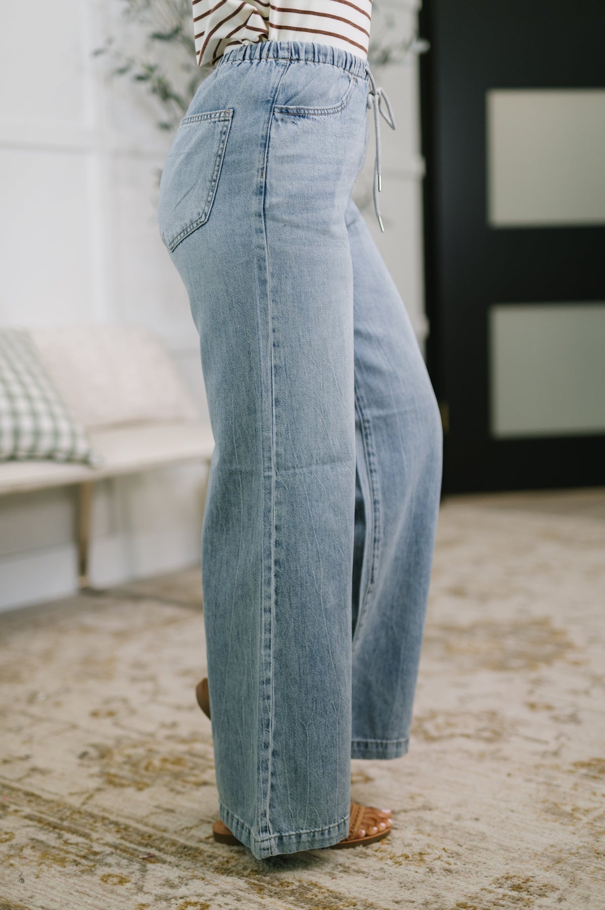 Person wearing light blue jeans with a blurred background
