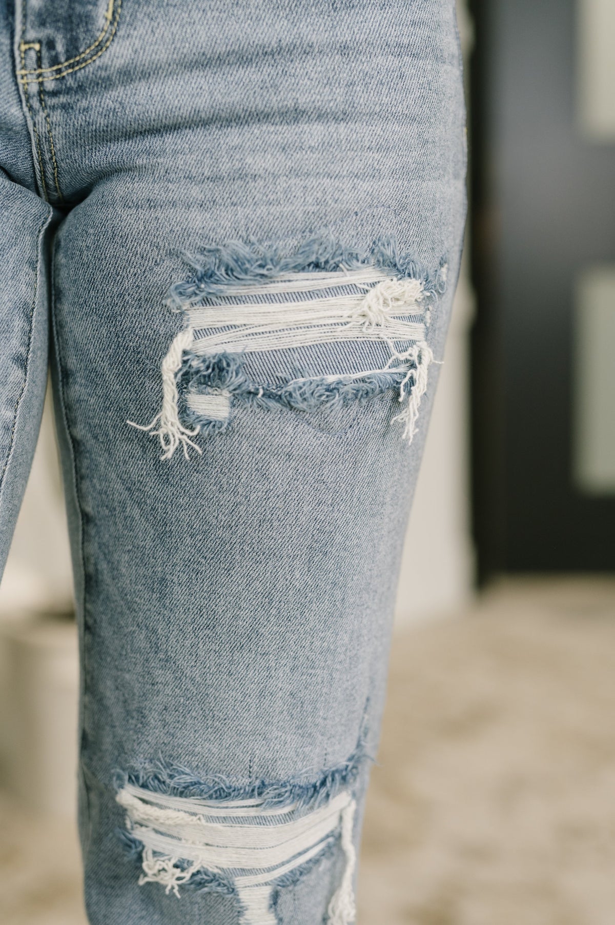 Close-up of distressed blue jeans with a blurred background