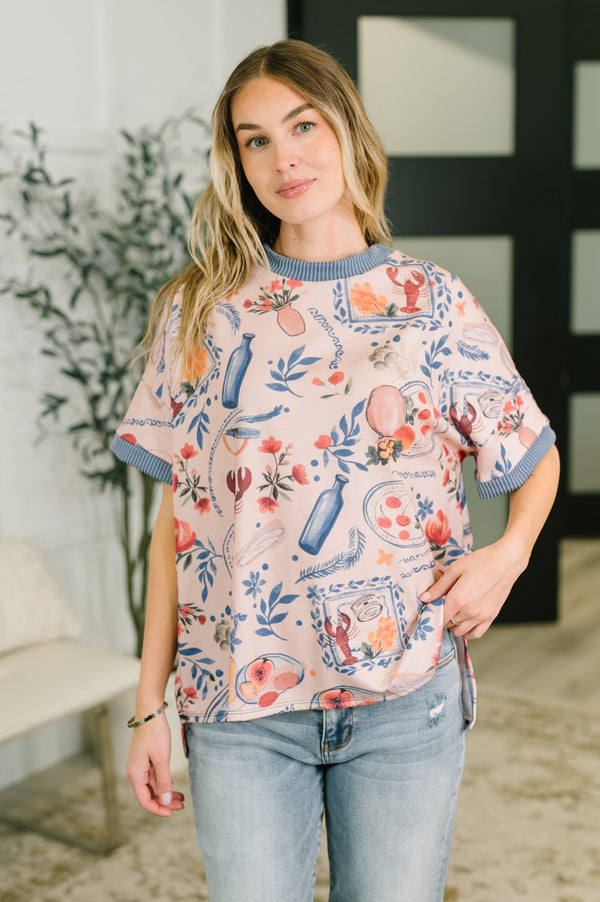 Woman wearing a floral patterned top with blue trim in an indoor setting