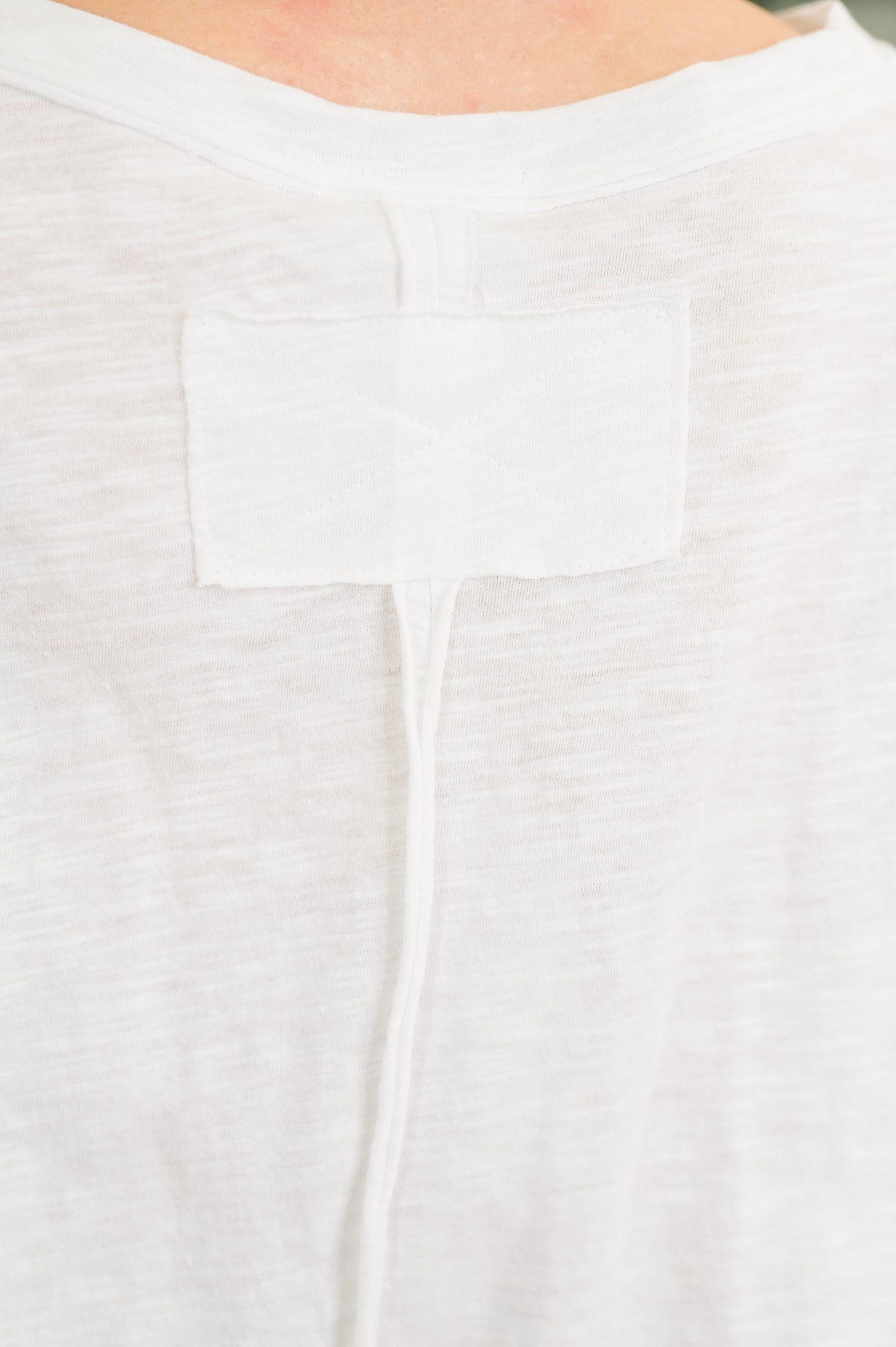 Close-up of a white garment with a pocket detail
