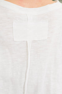 Close-up of a white garment with a pocket detail