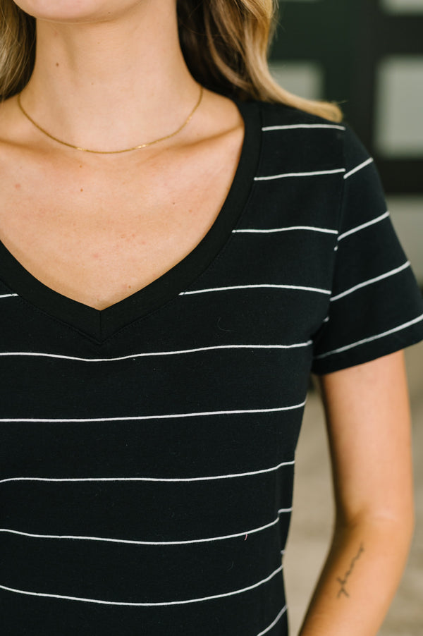 Black and white striped shirt worn by a person with a blurred background