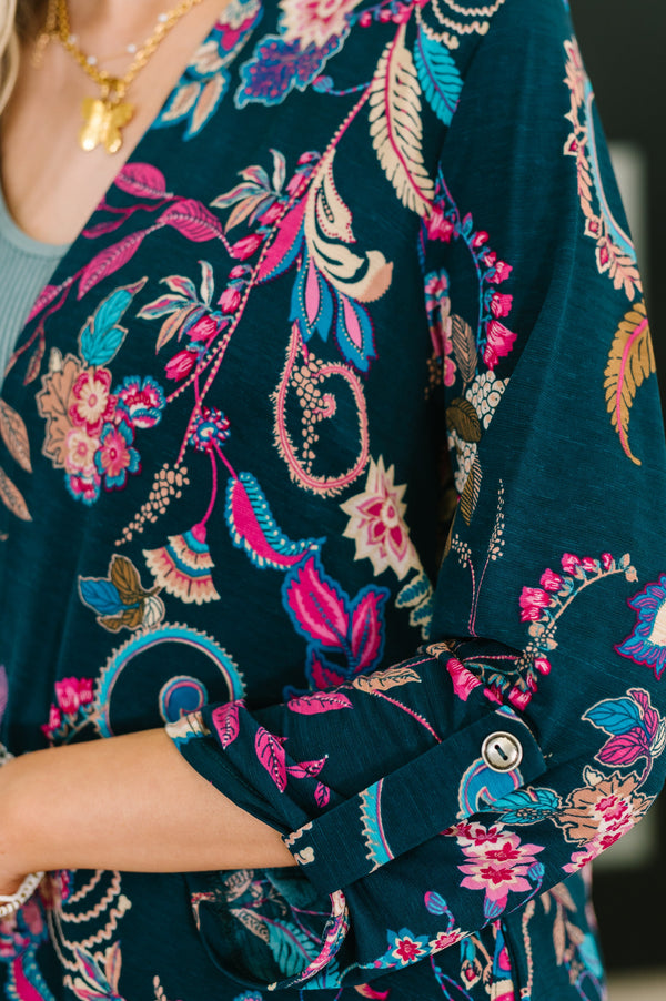 Close-up of a dark blue embroidered garment with floral and paisley patterns.