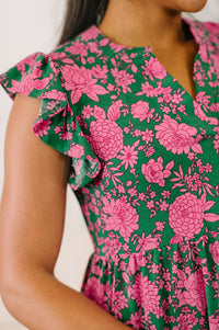 Close-up of a person wearing a green dress with pink floral pattern