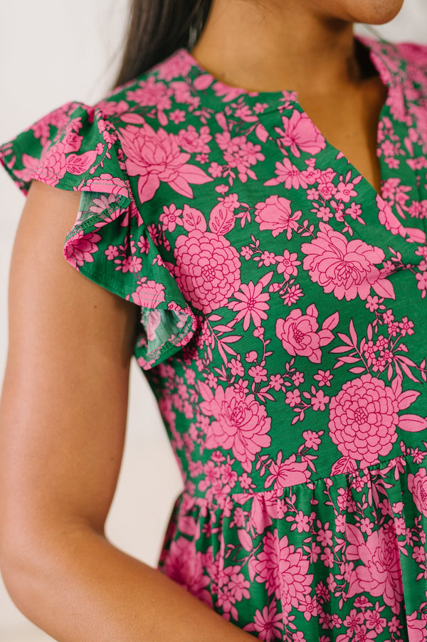 Close-up of a person wearing a green dress with pink floral pattern
