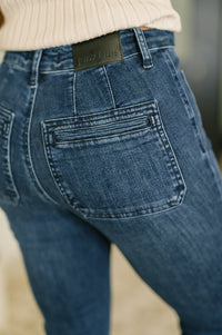 Close-up of blue jeans with a brand label on the waistband.