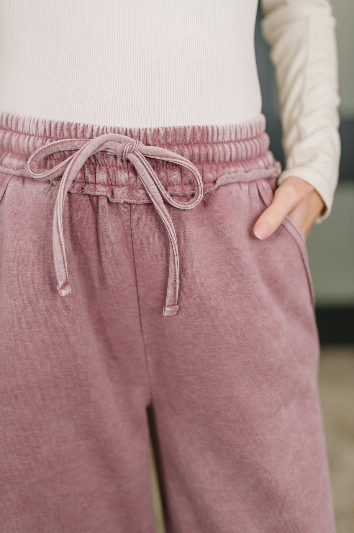 Person wearing pink sweatpants with a blurred background