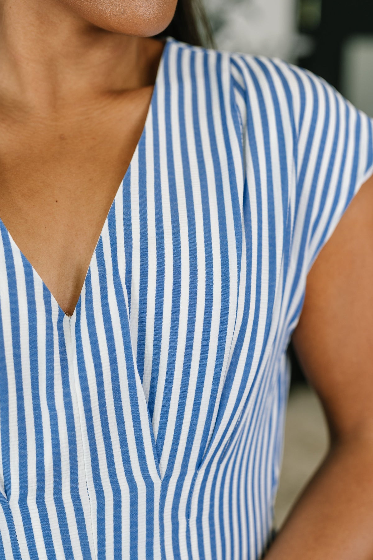 Close-up of a person wearing a blue and white striped shirt.