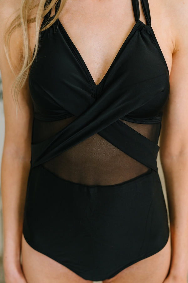 Black swimsuit with mesh panels worn by a person.