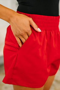 Red shorts worn by a person with a blurred background