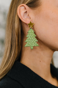Green Christmas tree earrings with a gold star on a blurred background