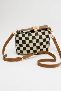 Checkered handbag with brown strap on a white background