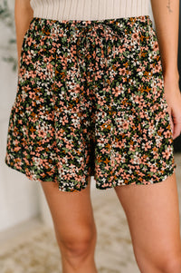 Floral shorts worn by a person with a blurred background