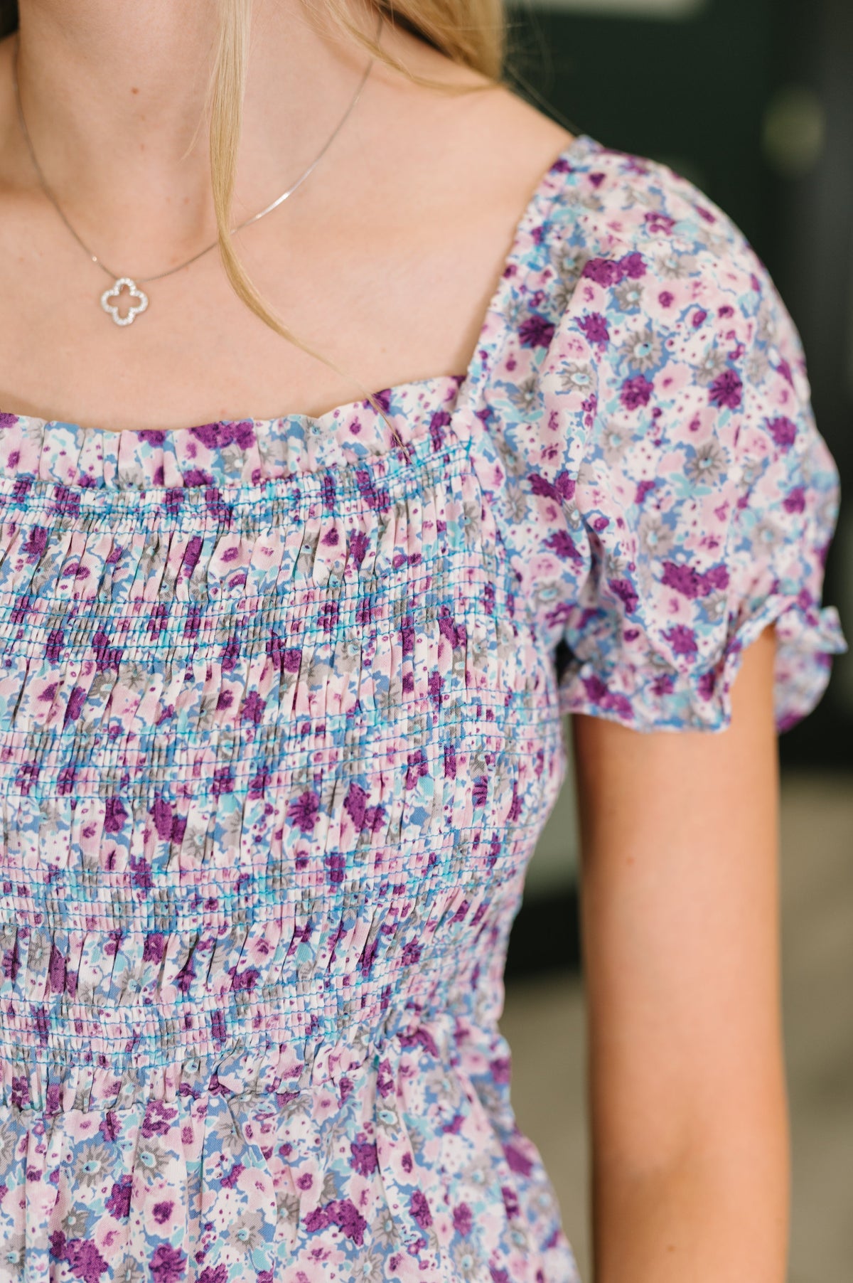 Close-up of a person wearing a floral dress with a blurred background