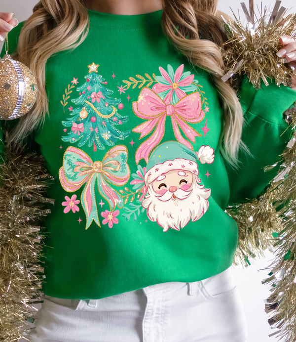 Green sweater with festive design featuring Santa Claus, trees, and bows, held by a person surrounded by gold tinsel.